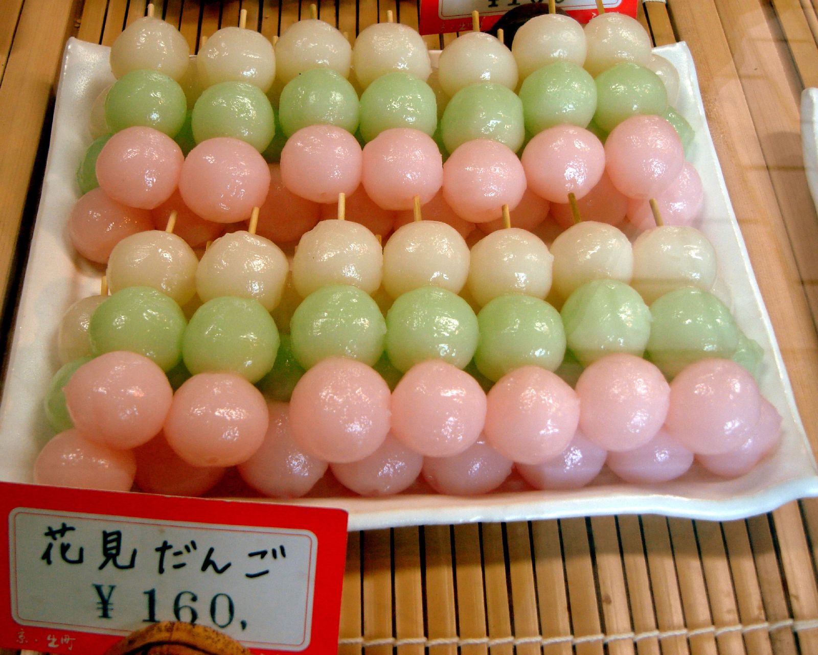 Pink, green and white hanami dango skewers displayed at a Japanese sweet shop