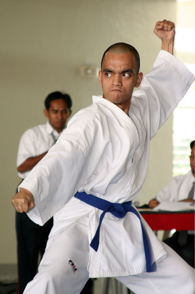 Karate practitioner in a white uniform performing a kata movement
