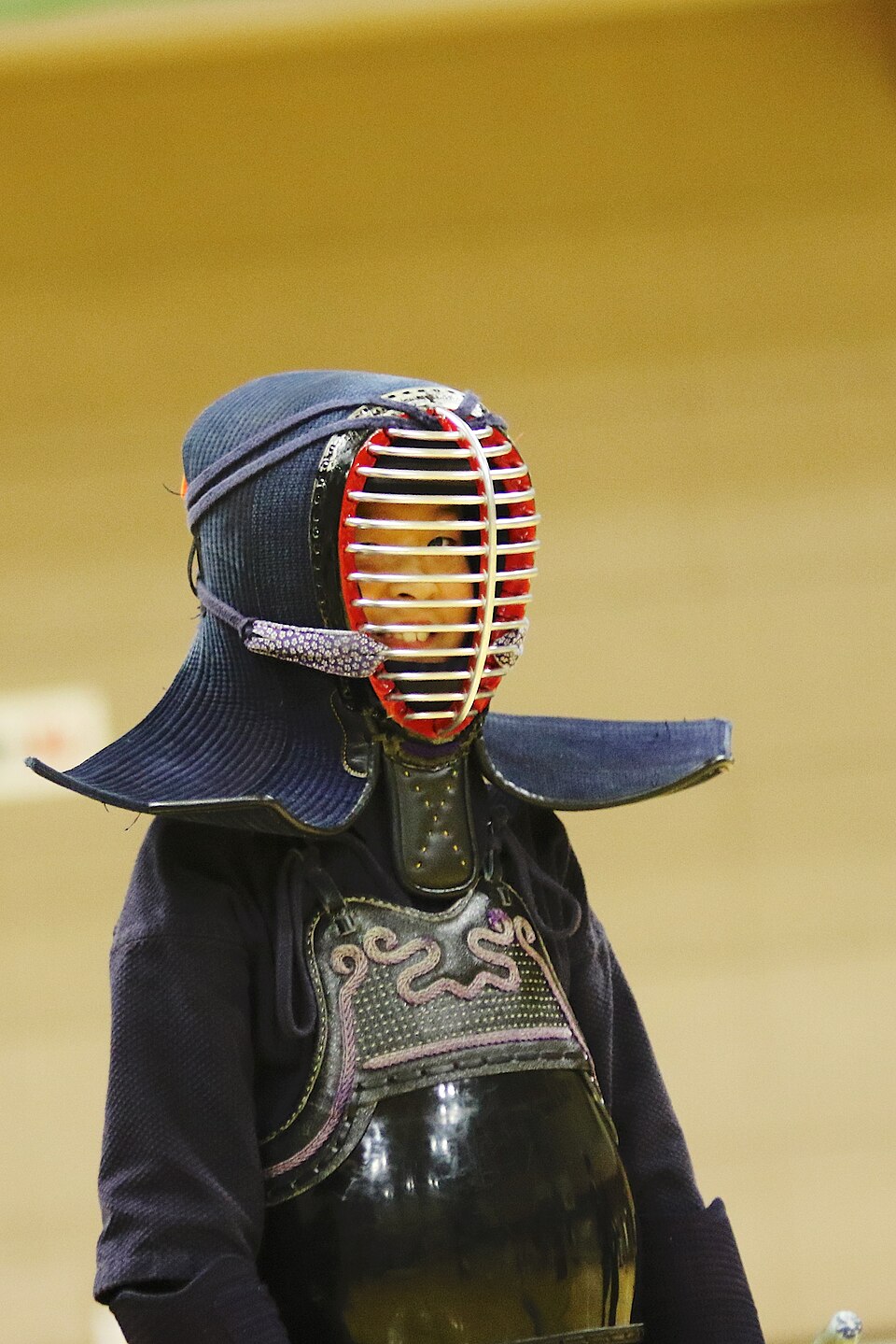 Kendo practitioner wearing a men helmet and protective armor